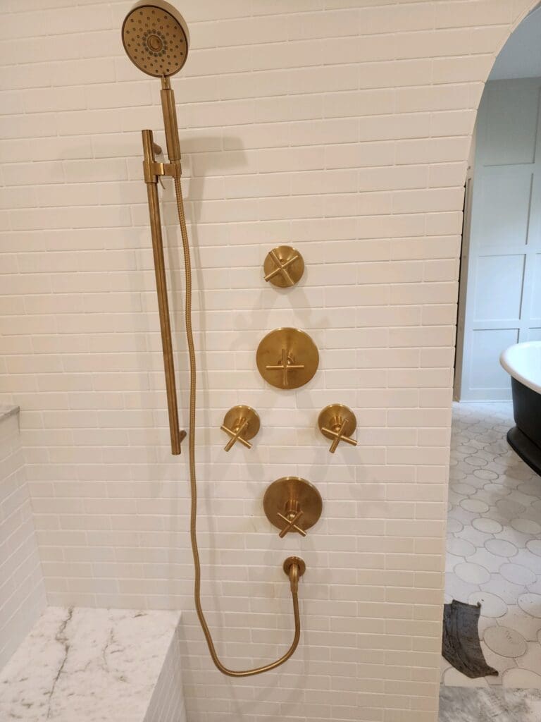 Modern shower fixtures on tiled wall