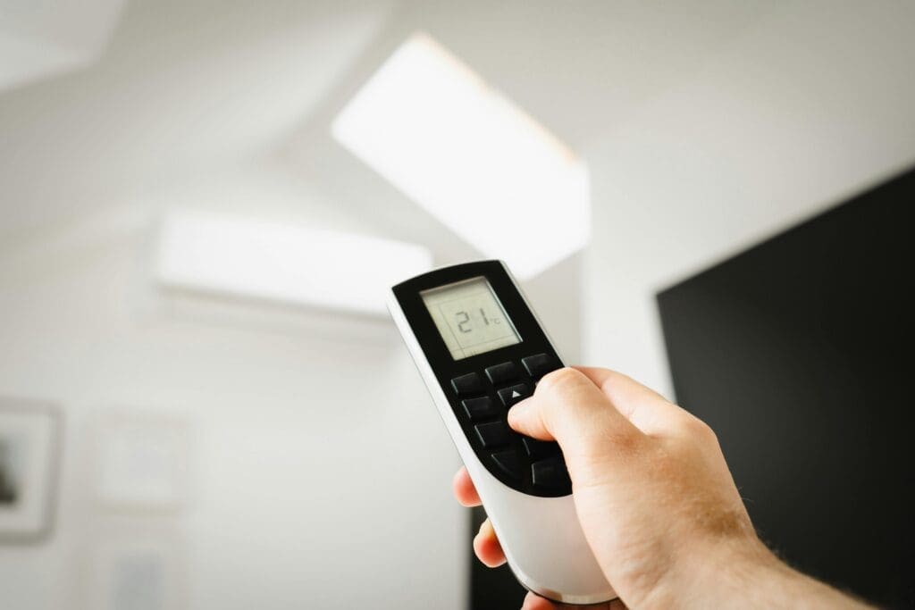 Hand holding remote control for air conditioning