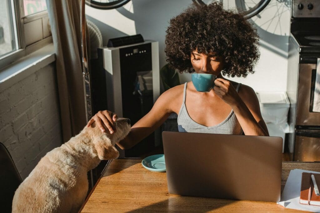 Person enjoying coffee with dog.