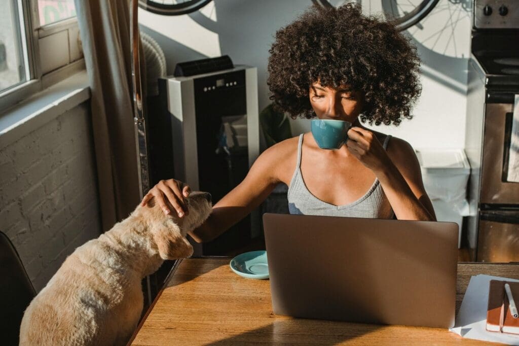 Person enjoying coffee with dog.