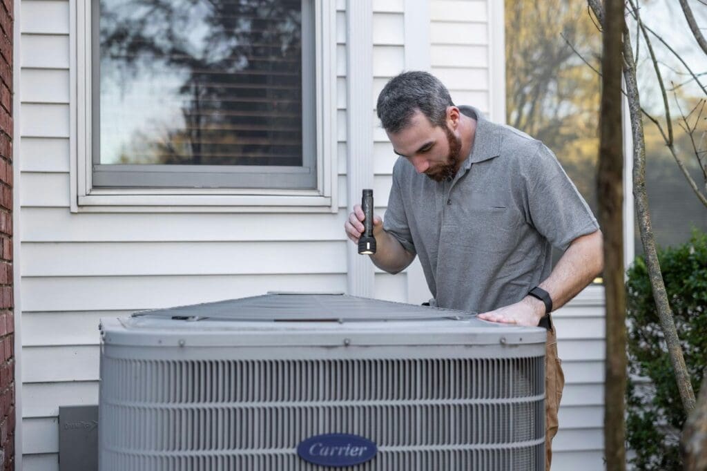 Man inspecting outdoor HVAC unit.