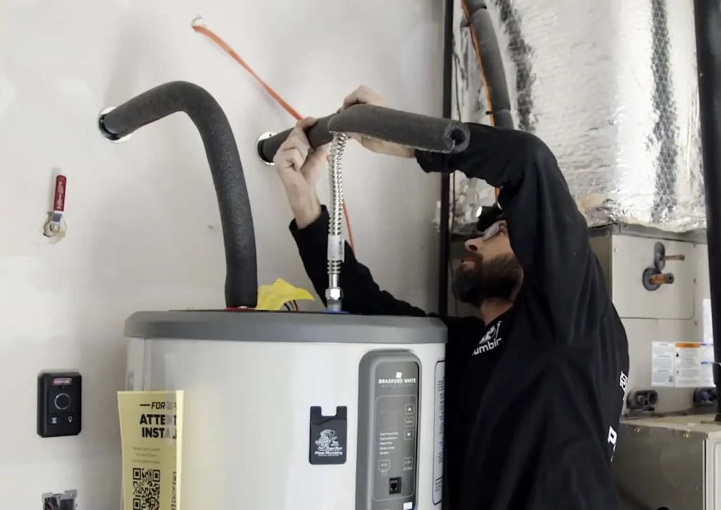 Man repairing water heater in basement
